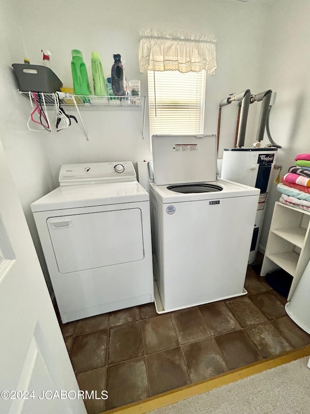 clothes washing area featuring water heater and washer and dryer