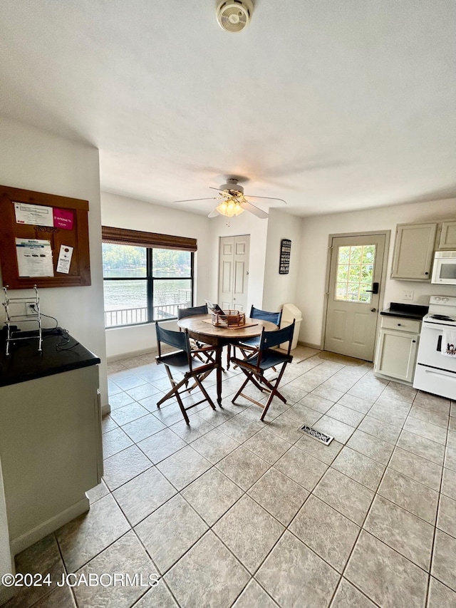 tiled dining room featuring ceiling fan and plenty of natural light