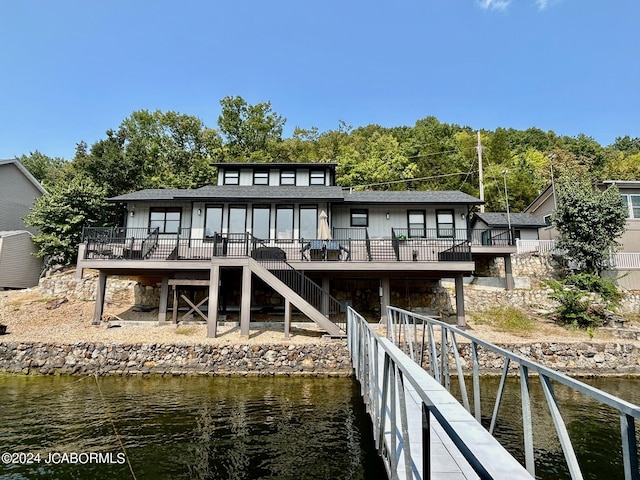 rear view of house featuring a deck with water view