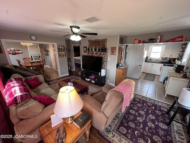 living area with a ceiling fan and tile patterned flooring
