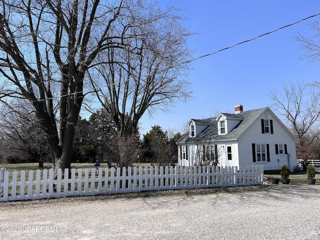 view of side of property with a chimney and a fenced front yard