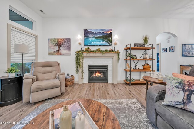 1308 Haxby Ct, Columbia, MO 65201 - living room with wood finished floors, arched walkways, a glass covered fireplace, and baseboards
