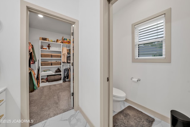 1308 Haxby Ct, Columbia, MO 65201 - bathroom featuring marble look tile flooring, toilet, baseboards, and a walk in closet