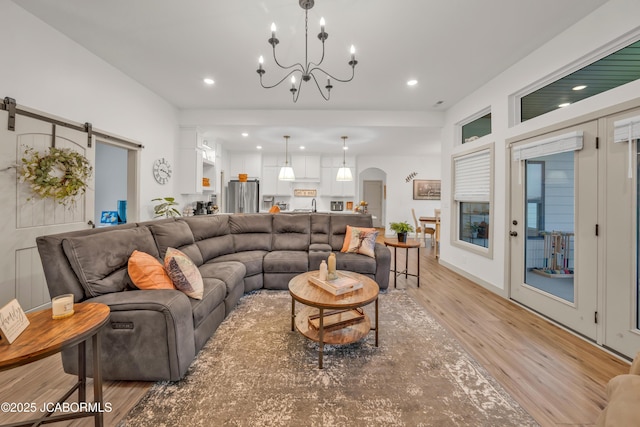 1308 Haxby Ct, Columbia, MO 65201 - living room featuring light wood-type flooring, a barn door, recessed lighting, arched walkways, and a chandelier