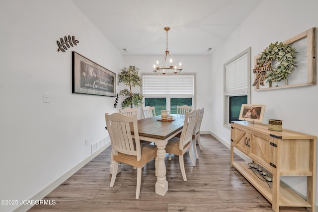 1308 Haxby Ct, Columbia, MO 65201 - dining room featuring a chandelier, light wood finished floors, and baseboards