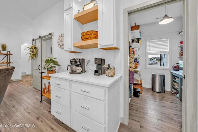 1308 Haxby Ct, Columbia, MO 65201 - kitchen featuring open shelves, a barn door, light countertops, and light wood-style flooring