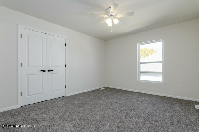 carpeted empty room with visible vents, baseboards, and a ceiling fan