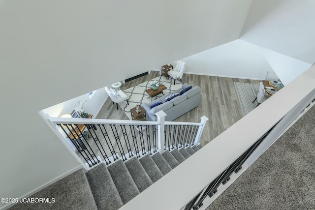 stairway featuring baseboards, vaulted ceiling, and wood finished floors