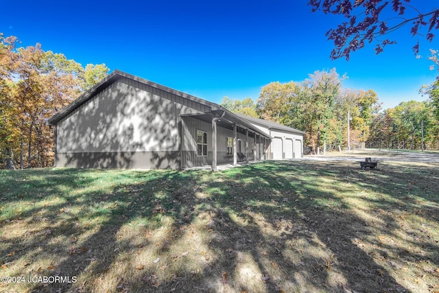 view of side of home featuring a garage and a yard
