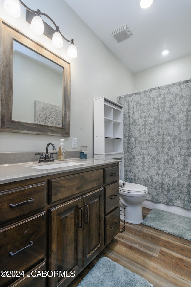 bathroom featuring walk in shower, toilet, vanity, and hardwood / wood-style flooring