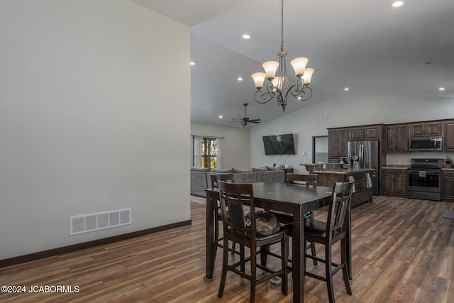 dining area with ceiling fan with notable chandelier, dark wood-type flooring, and high vaulted ceiling