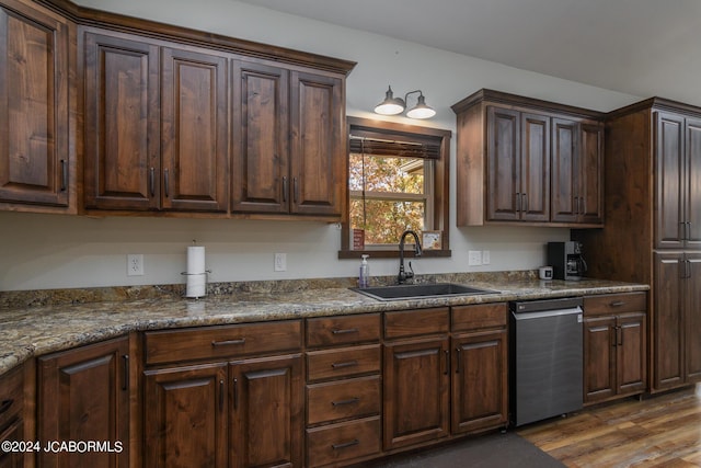kitchen with dark hardwood / wood-style flooring, dark stone counters, dark brown cabinets, sink, and dishwasher