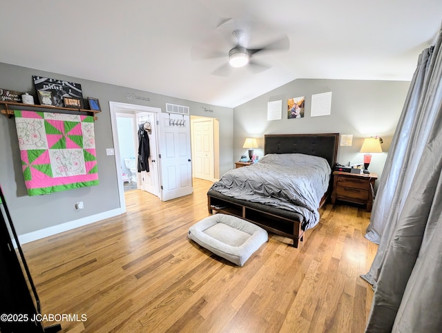 bedroom with vaulted ceiling, light wood-style flooring, visible vents, and baseboards