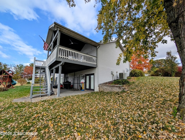 back of property featuring ceiling fan, stairway, a deck, a yard, and central air condition unit