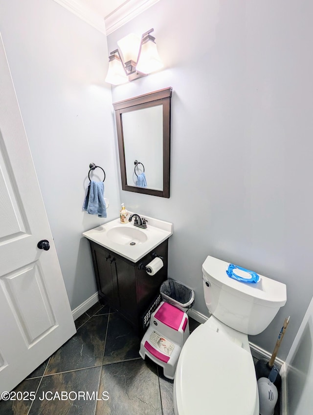 half bathroom with ornamental molding, baseboards, vanity, and toilet