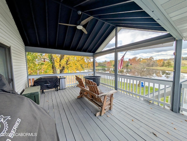 deck with a water view and a ceiling fan