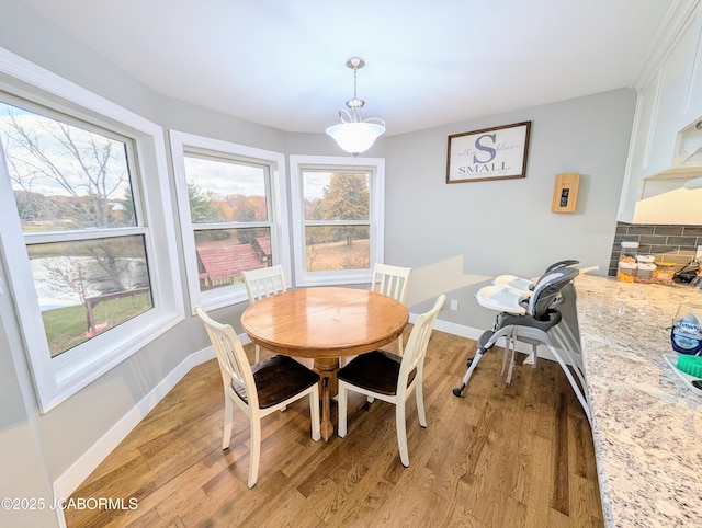 dining room featuring plenty of natural light, light wood-style flooring, and baseboards