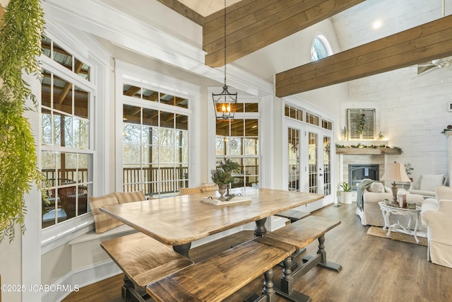 dining room featuring hardwood / wood-style flooring, beam ceiling, and high vaulted ceiling