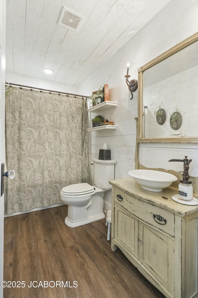 bathroom with a shower with shower curtain, vanity, toilet, and wood-type flooring