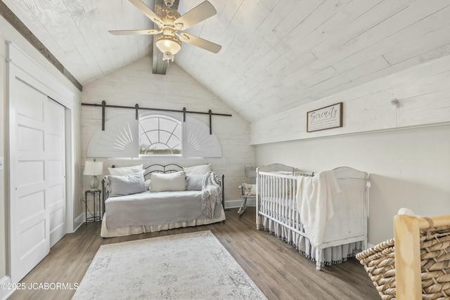 bedroom featuring wooden ceiling, lofted ceiling, hardwood / wood-style flooring, ceiling fan, and a closet