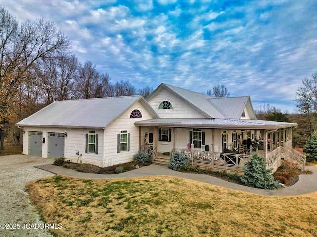 view of front of home with a front yard, a porch, and a garage