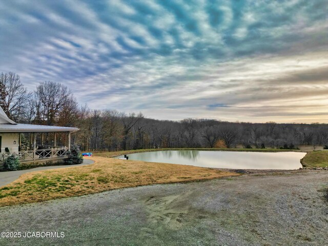 yard at dusk featuring a water view