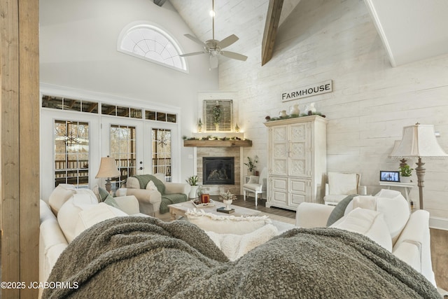 living room with beamed ceiling, hardwood / wood-style flooring, high vaulted ceiling, and ceiling fan