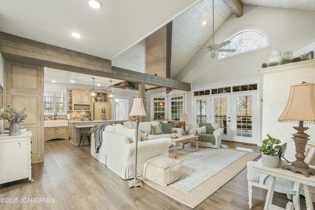 living room with ceiling fan, french doors, sink, high vaulted ceiling, and light wood-type flooring