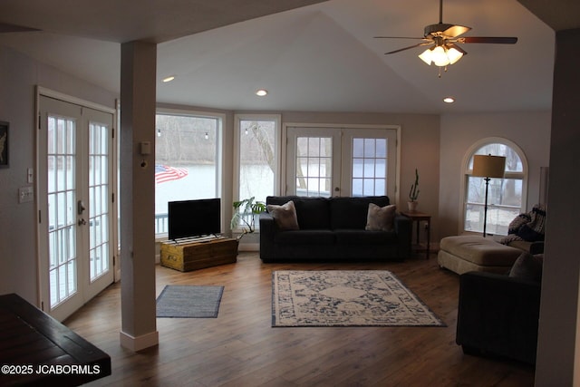 living room featuring lofted ceiling, french doors, a healthy amount of sunlight, and wood finished floors