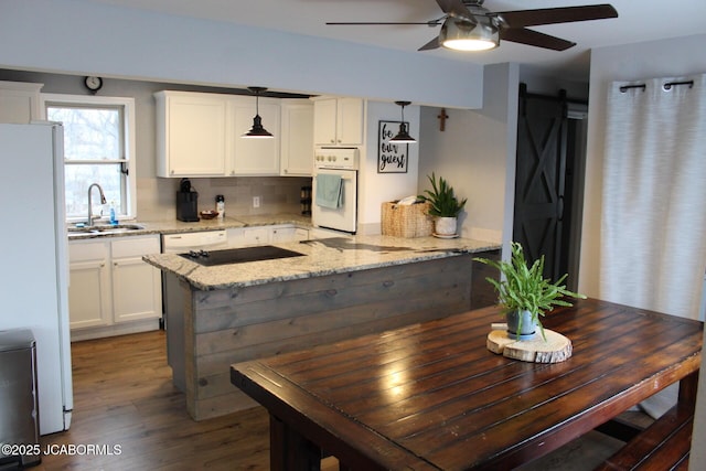 kitchen featuring light stone counters, white appliances, decorative light fixtures, and white cabinets