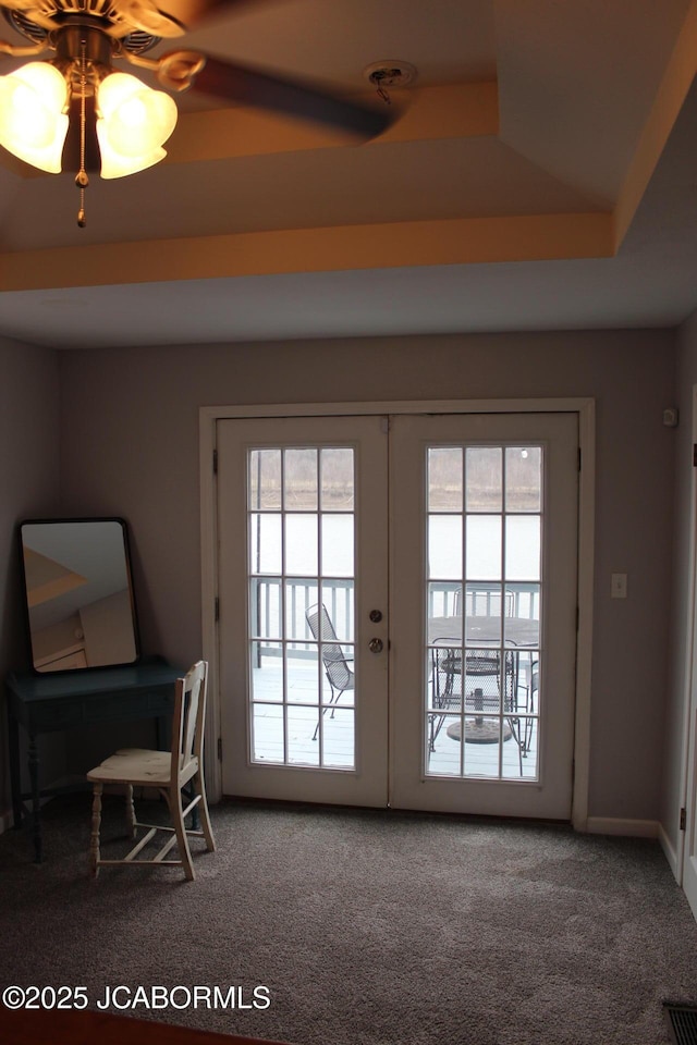 doorway to outside featuring a raised ceiling, french doors, carpet flooring, and visible vents