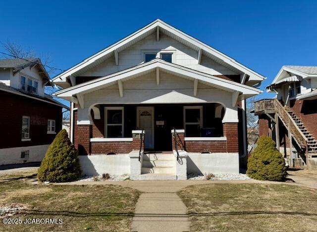 view of front facade with covered porch and brick siding