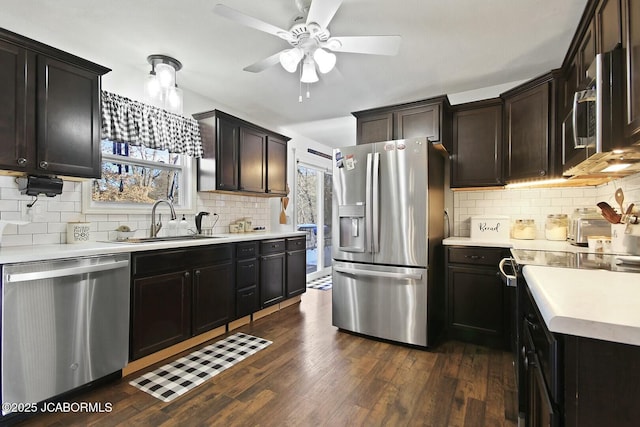 kitchen featuring sink, ceiling fan, backsplash, dark hardwood / wood-style floors, and appliances with stainless steel finishes