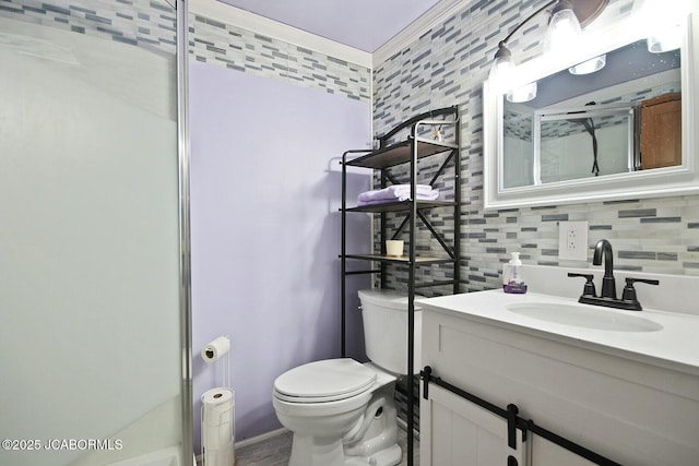 bathroom with toilet, a shower with door, vanity, and tasteful backsplash