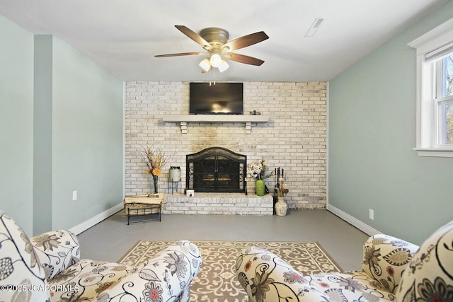 living room with a fireplace, concrete flooring, and ceiling fan