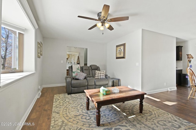 living room featuring dark hardwood / wood-style flooring and ceiling fan