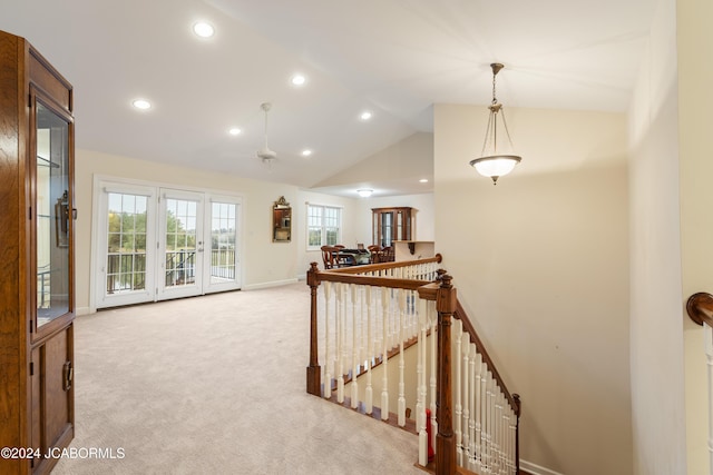 hall featuring light carpet and vaulted ceiling