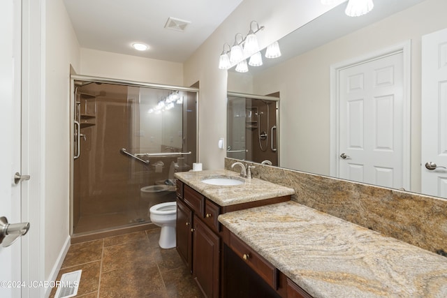 bathroom featuring vanity, a shower with shower door, and toilet