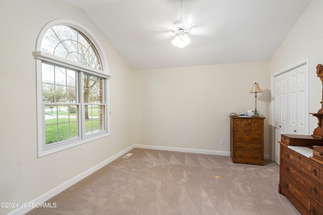 carpeted bedroom featuring a closet, vaulted ceiling, and ceiling fan