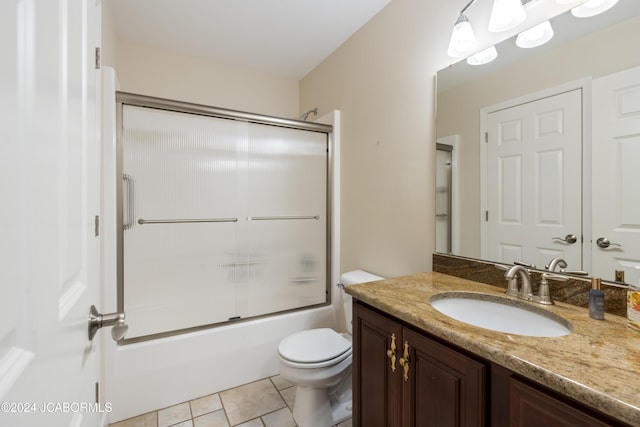 full bathroom with tile patterned floors, vanity, toilet, and shower / bath combination with glass door