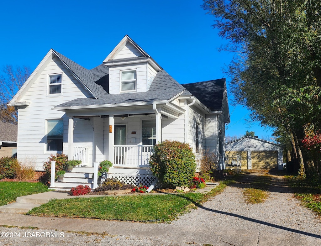 view of front of home with covered porch, an outdoor structure, and a garage