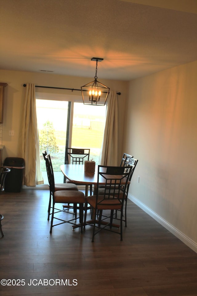 dining room with baseboards, dark wood-type flooring, and an inviting chandelier