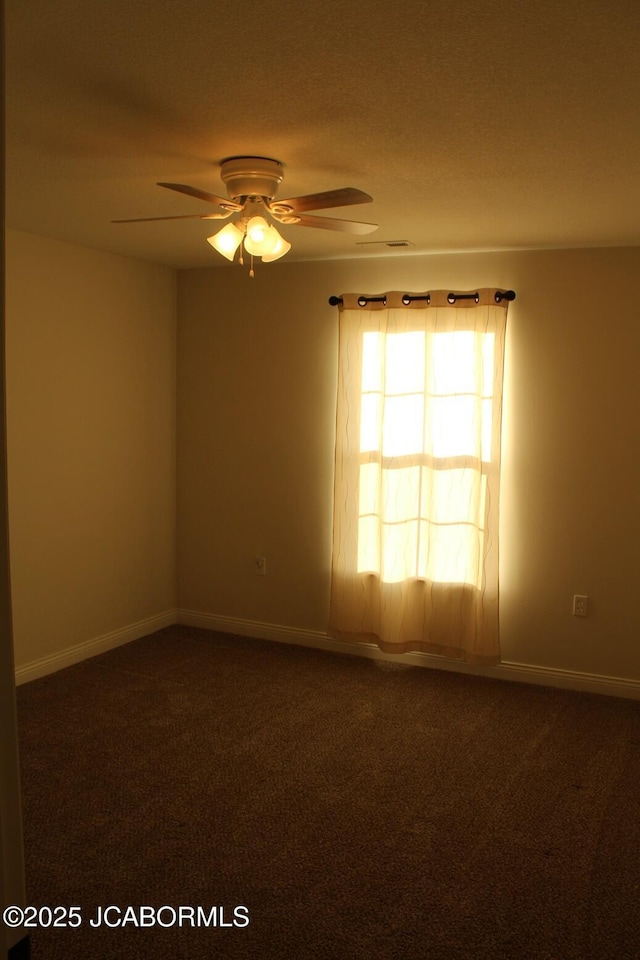 carpeted empty room with baseboards and a ceiling fan