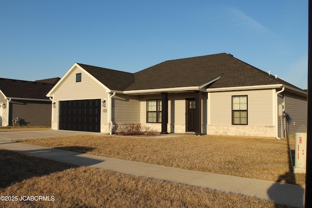 view of front of house featuring a garage, stone siding, roof with shingles, and driveway