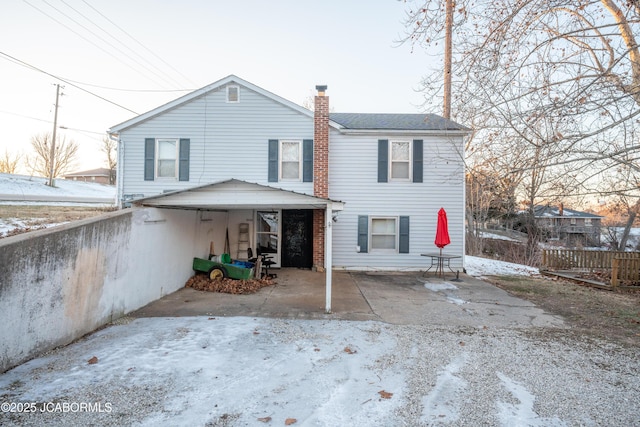 snow covered property featuring a chimney