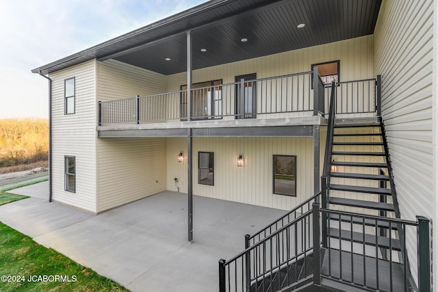 rear view of house featuring a patio area and a balcony