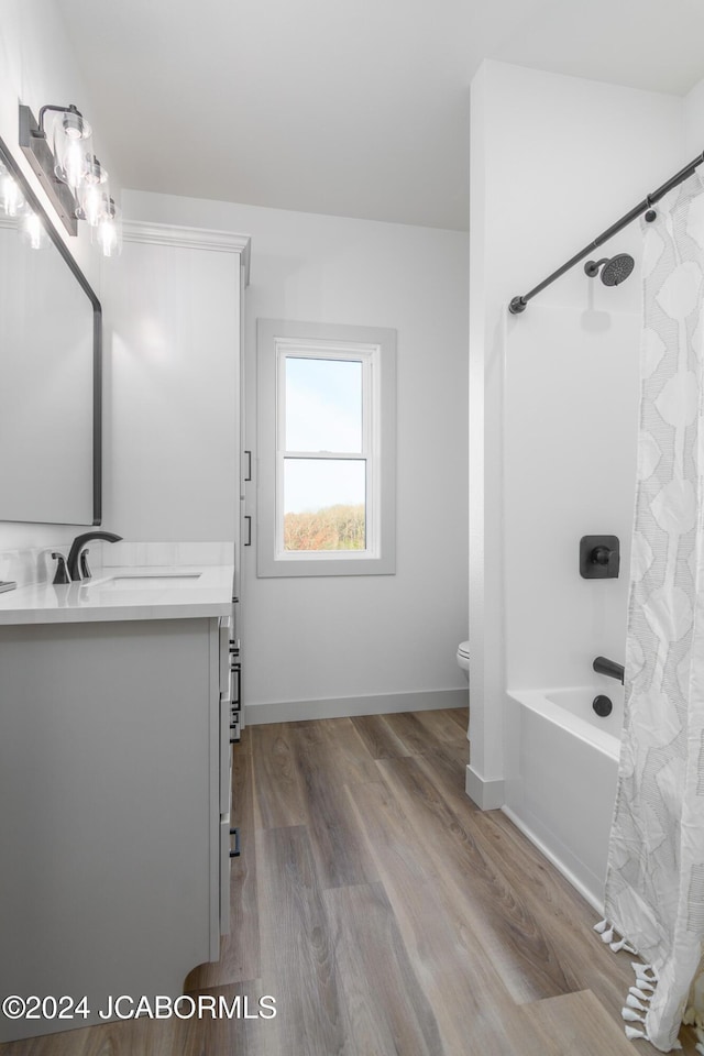 full bathroom featuring hardwood / wood-style floors, vanity, toilet, and shower / bath combo with shower curtain