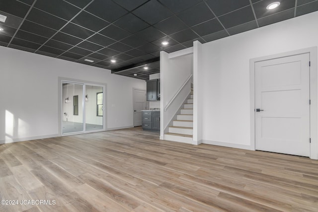 unfurnished living room with hardwood / wood-style floors and a drop ceiling