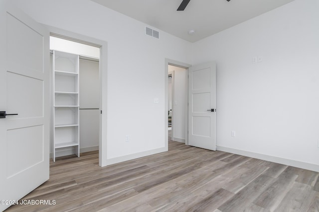 unfurnished bedroom with ceiling fan and light hardwood / wood-style flooring