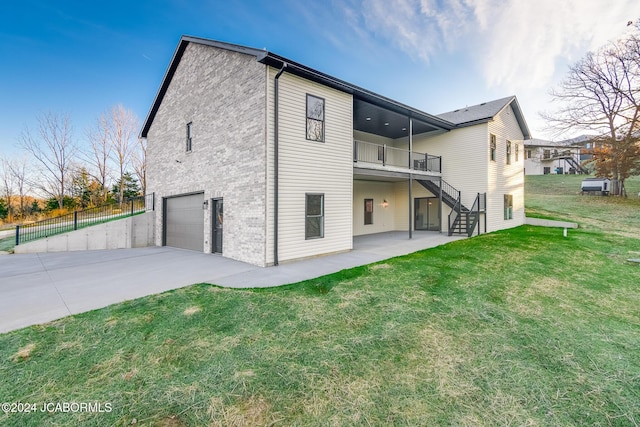 back of house with a patio, a balcony, a garage, and a lawn